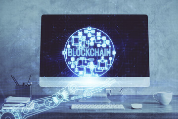Double exposure of blockchain theme hologram and table with computer background. Concept of bitcoin crypto currency.