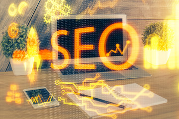 Multi exposure of table with computer and seo drawing hologram. Search optimization concept.
