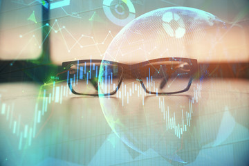 Financial graph hologram with glasses on the table background. Concept of business. Double exposure.
