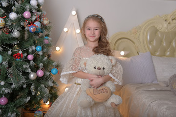 vintage portrait of a little girl in alabaster elegant dress with a toy bear