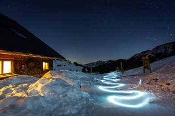Germany, Bavaria, Allgaeu Alps, winter night scene with old mountain hut and light painting