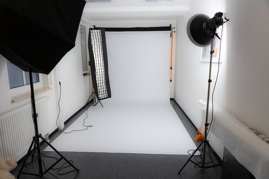 Photo studio with strip light, soft bix, beauty dish and a white backdrop