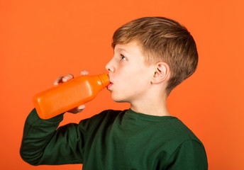 Sweet treat packed with essential nutrition. Small child drink juice orange background. Little boy enjoy drinking fruit juice. Juice as healthy part of kids diet. Kid friendly juice recipe