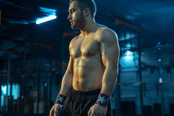 Fototapeta na wymiar Caucasian man practicing in weightlifting in gym. Caucasian male sportive model posing before training, looks confident and strong. Body building, healthy lifestyle, movement, activity, action concept