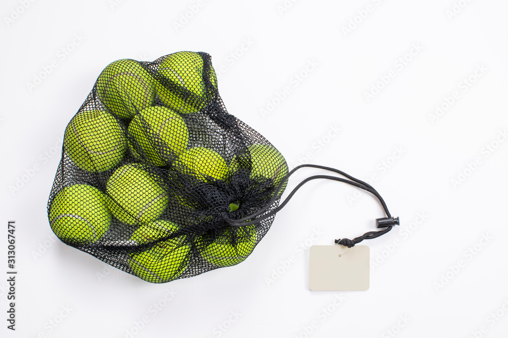 Wall mural Tennis balls in net bag, isolated background. Top view