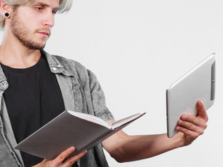 Man student holding tablet and book.
