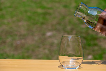 Prepare to pouring pure water in to the glass with background nature