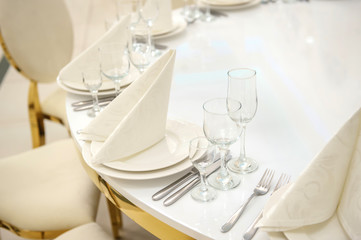 close up photo of a white arranged table in a vintage style in a wedding banquet hall