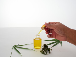 Hand with pipettes and cannabis extract oil.