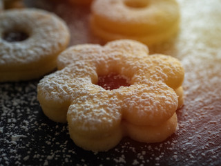 Homemade Linzer Christmas cookies. Biscuits with shortcrust pastry and strawberry jam on dark background.