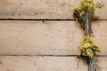dried herbs laid out on the edge on a wooden background