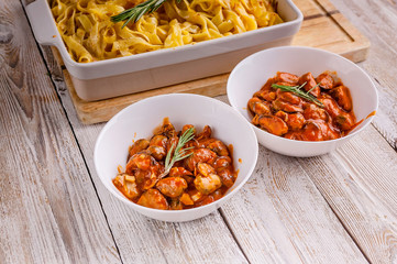 Mussels in tomato sauce and fettuccine in a ceramic bowl on a wooden table. Italian pasta. Close-up. Copy space