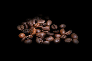 Several coffee beans on an isolated black background