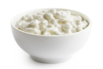 White ceramic bowl of chunky cottage cheese isolated on white.