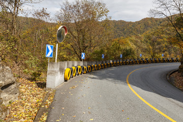 asphalt road in the mountains of China, convex mirror and car wheels for safety
