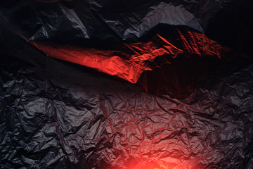abstract black-and-red texture made of crumpled polyethylene