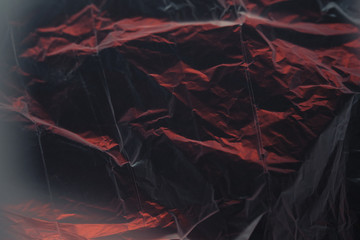 abstract black-and-red texture made of crumpled polyethylene