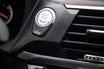 Close-up of a start-stop button on a dashboard in a modern premium luxury car. close-up, soft focus.