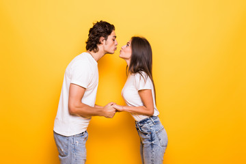 Young couple in love kiss isolated yellow background - obrazy, fototapety, plakaty