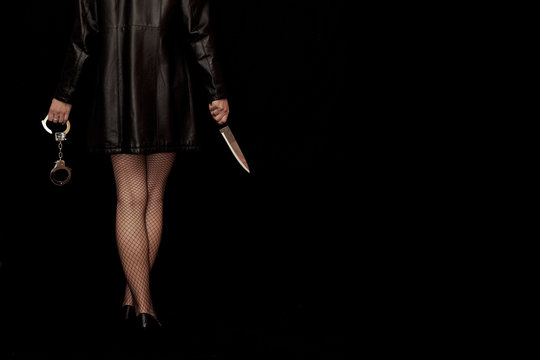 Frau in Netzstrümpfen mit Handschellen und Messer