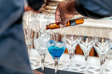 Shallow focus shot of a person pouring an alcoholic drink into the glass