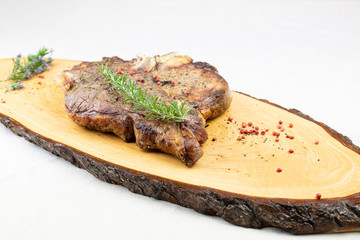 Florentine steak, beef cooked on the grill Italian style. Slice of meat cooked on the barbecue on a wooden cutter built with a slice of a tree.