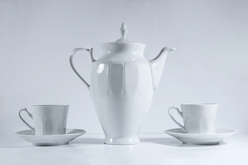 White retro coffee or tea pot with cups on white background..