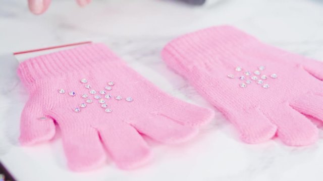 Rhinestone pink kids gloves with snowflake shapes.