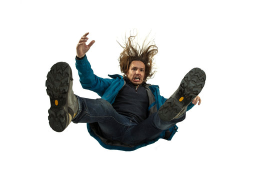 A second before falling. Caucasian young man falling down in moment with bright emotions and facial expression. Male model in casual clothes on white. Shocked, scared, screaming. Copyspace for ad.