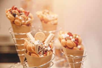 Hong kong or bubble waffle with strawberries candy ice cream on bakery shop counter in italy venice