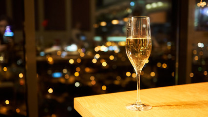 A glass of champagne on a table in a restaurant.