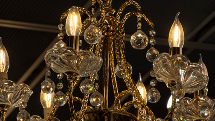 Chandelier.Home, beautiful chandelier.A luxurious lamp hangs from the ceiling.Brass chandelier with crystal.Chandelier ceiling lights, background with copy space. Closeup.
