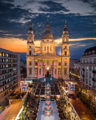 Budapest, Hungary - Aerial drone view of Europe's most beautiful Christmas market with the illuminated St.Stephen's Basilica, Ice rink, Christmas tree and clear blue sky .at dusk