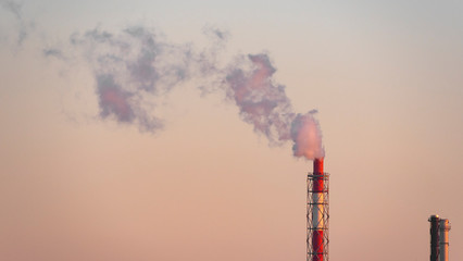 Striped Smoking chimney of the heating plant of the station at dawn.  Factory in town. Heating of the city. Environmental pollution, ecology. Landscape.