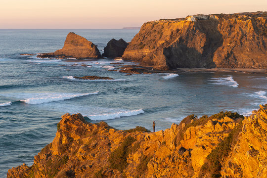 Woman on a cliff at Praia de Odeceixe in Costa Vicentina, Portugal