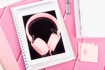 music while working. Pink headphones on table or desk, 