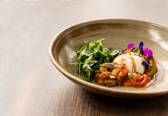 You are what you eat. A salad with burrata cheese, tomatoes and arugula dressed with olive oil, in stylish plate. Healthy, summer food concept. Horizontal shot. Copy space on the left side