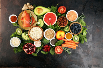 Healthy food clean eating selection: fish, fruit, vegetable, cereal, leaf vegetable on rustic background