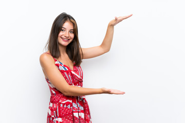 Caucasian girl in red dress over isolated white wall holding copyspace to insert an ad