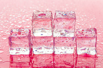 Fozen ice cubes on wet pink background