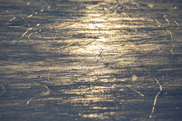 bright traces of ice skating on an ice rink. background and texture. reflection in the sunlight