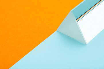 bright triangular prism on orange-blue background, minimalism, abstraction