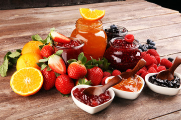 assortment of jams, seasonal berries jelly, mint and fruits and tangerine
