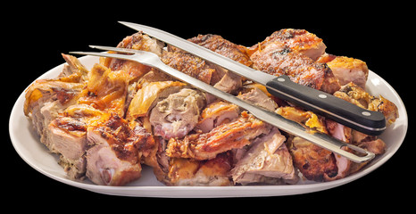 Plateful of Fresh Spit Roasted Pork Meat Slices Offered with Serving Knife and Fork on Oblong Porcelain Tray Isolated on Black Background