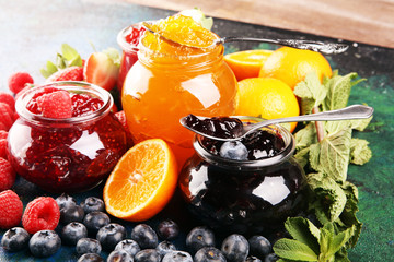 assortment of jams, seasonal berries jelly, mint and fruits and tangerine