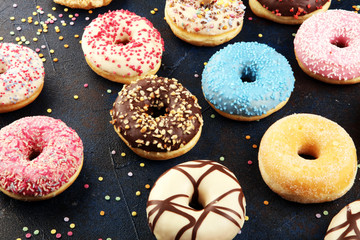 assorted donuts with chocolate frosted, pink glazed and sprinkles donuts