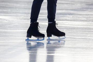 feet on the skates of a person rolling on the ice rink
