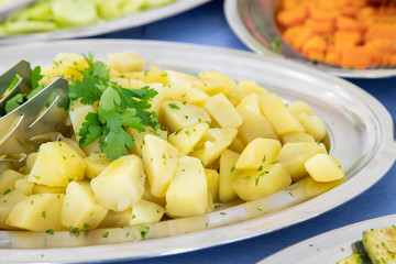 Breakfast buffet in hotel restaurant. Tray of boiled potatoes with parsley