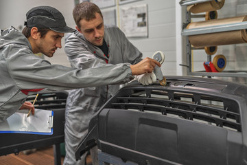 An employee of the paint shop of the automobile plant conducts training on the preparation of...