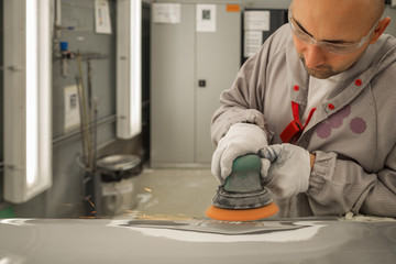 Worker in the paint shop, grinds and cleans the body element